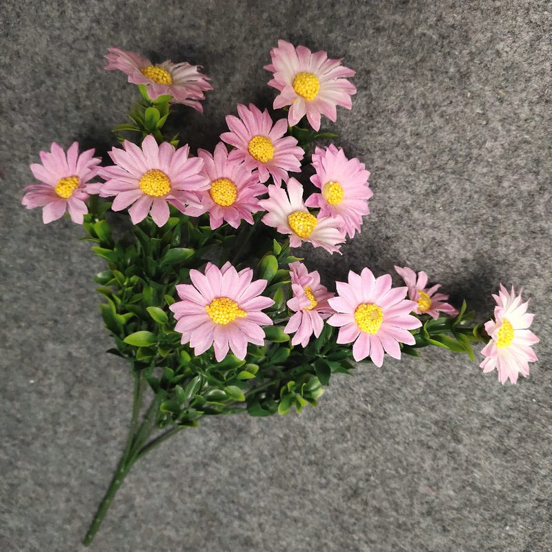 Artificial daisy are made of silk cloth and is available in 7 colors. Fake daisy flowers are used for decor Outdoor, front porch, back deck, garden, balcony, terrace, patio, reservation area, hotel and restaurant. Faux daisy arrangements can be paired with Begonias, ornamental cabbages, dahlias, roses, tulips, lilies, berries., etc. Leafhometrade specializes in providing wholesale custom artificial daisy.