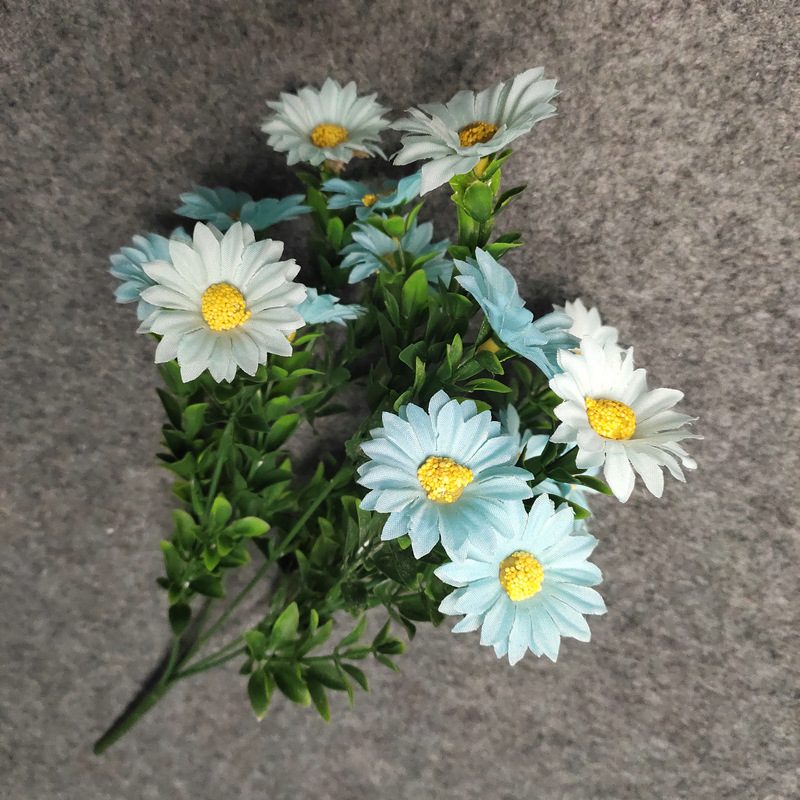 Artificial daisy are made of silk cloth and is available in 7 colors. Fake daisy flowers are used for decor Outdoor, front porch, back deck, garden, balcony, terrace, patio, reservation area, hotel and restaurant. Faux daisy arrangements can be paired with Begonias, ornamental cabbages, dahlias, roses, tulips, lilies, berries., etc. Leafhometrade specializes in providing wholesale custom artificial daisy.