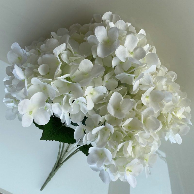 Artificial hydrangeas are made of fabric cloth, available in 17 colors. Artificial hydrangeas flowers are used for ‎Home decoration, party venue decoration, wedding venue decoration, exquisite bouquet design, flower box design, flower basket design. Hydrangea flower arrangements can be paired with delphiniums, freesias, foxgloves, greenery, bells, and more. Use hydrangeas in different colors to create a more vibrant floral arrangement for special occasions. Add some greenery to your flower arrangement to fill in the gaps and add visual interest. Use a vase or container in the same color as the hydrangeas for a more cohesive look. Leafhometrade specializes in providing wholesale custom artificial plants.