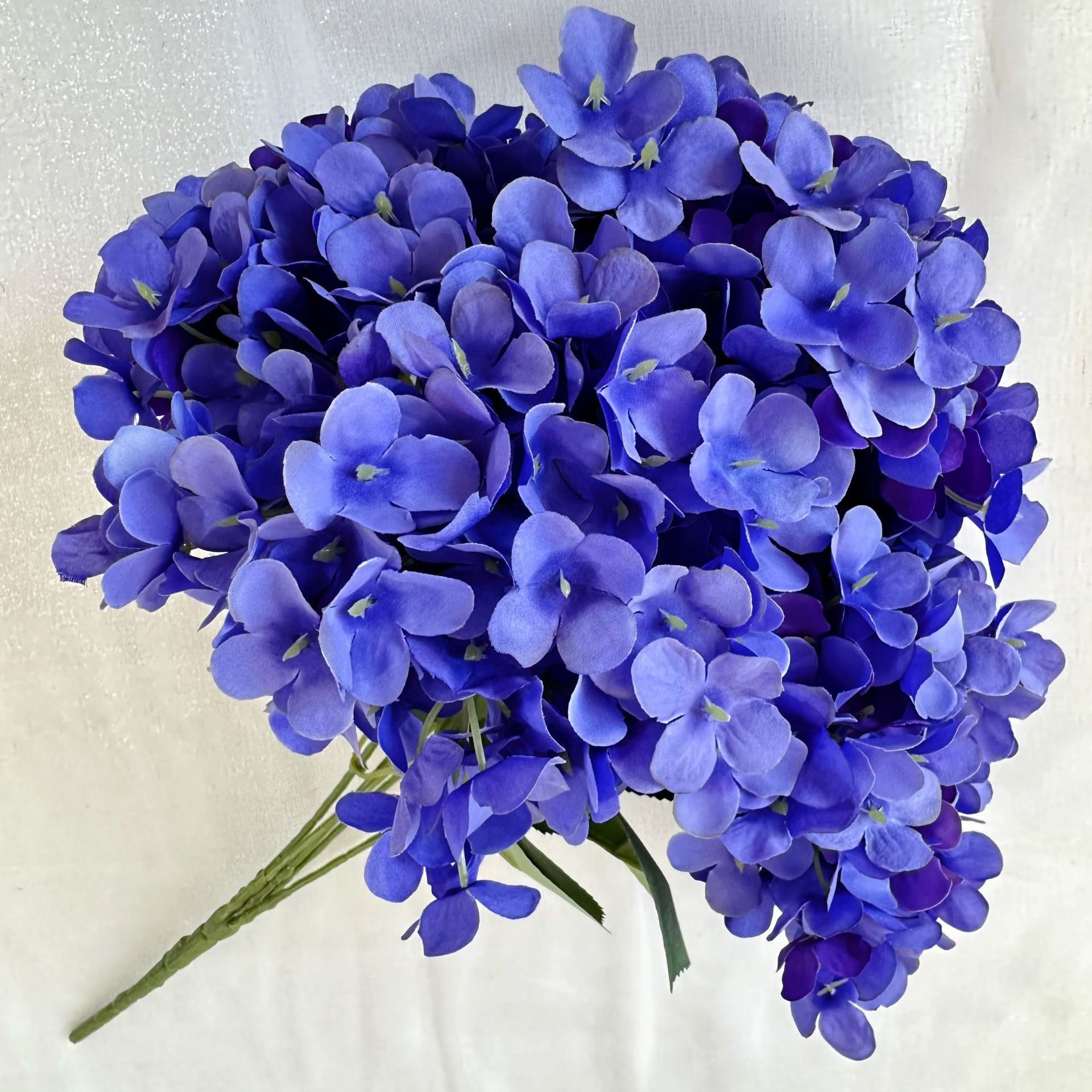 Artificial hydrangeas are made of fabric cloth, available in 17 colors. Artificial hydrangeas flowers are used for ‎Home decoration, party venue decoration, wedding venue decoration, exquisite bouquet design, flower box design, flower basket design. Hydrangea flower arrangements can be paired with delphiniums, freesias, foxgloves, greenery, bells, and more. Use hydrangeas in different colors to create a more vibrant floral arrangement for special occasions. Add some greenery to your flower arrangement to fill in the gaps and add visual interest. Use a vase or container in the same color as the hydrangeas for a more cohesive look. Leafhometrade specializes in providing wholesale custom artificial plants.